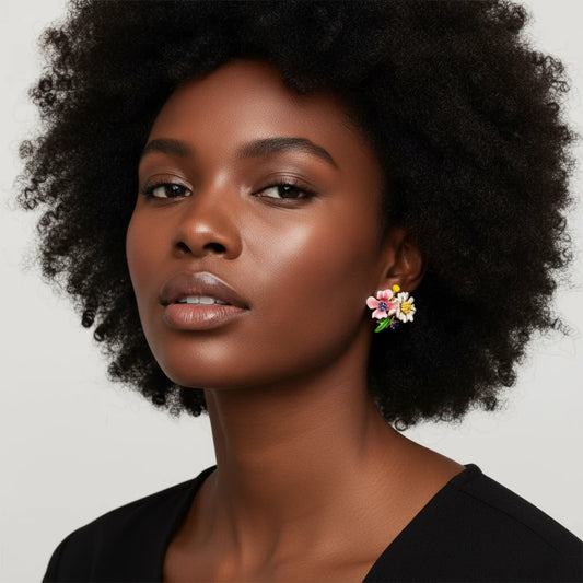 Detailed view of gold-plated brass stud earrings featuring multicolor enamel flowers with white, pink, and blue petals