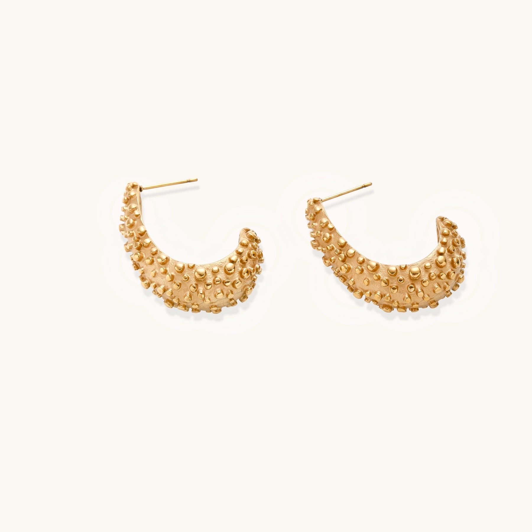 Pair of gold-plated hoop earrings with raised dotted texture surface shown from multiple angles on white background.